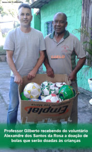 Professor Gilberto recebendo do voluntário Alexandre dos Santos da Rosa a doação de bolas que serão doadas às crianças - Foto Gustavo Cruz-O Jornalecão